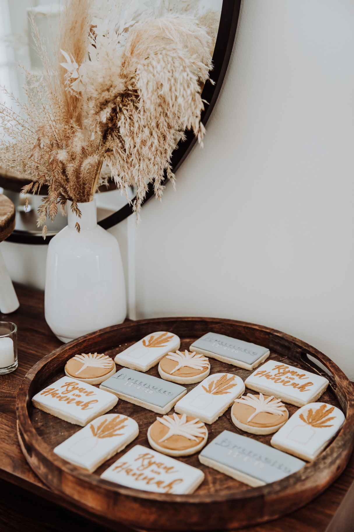 Boho wedding cookies with gold pampas, palms, and hand-lettered Ryan and Hannah names on a wooden tray