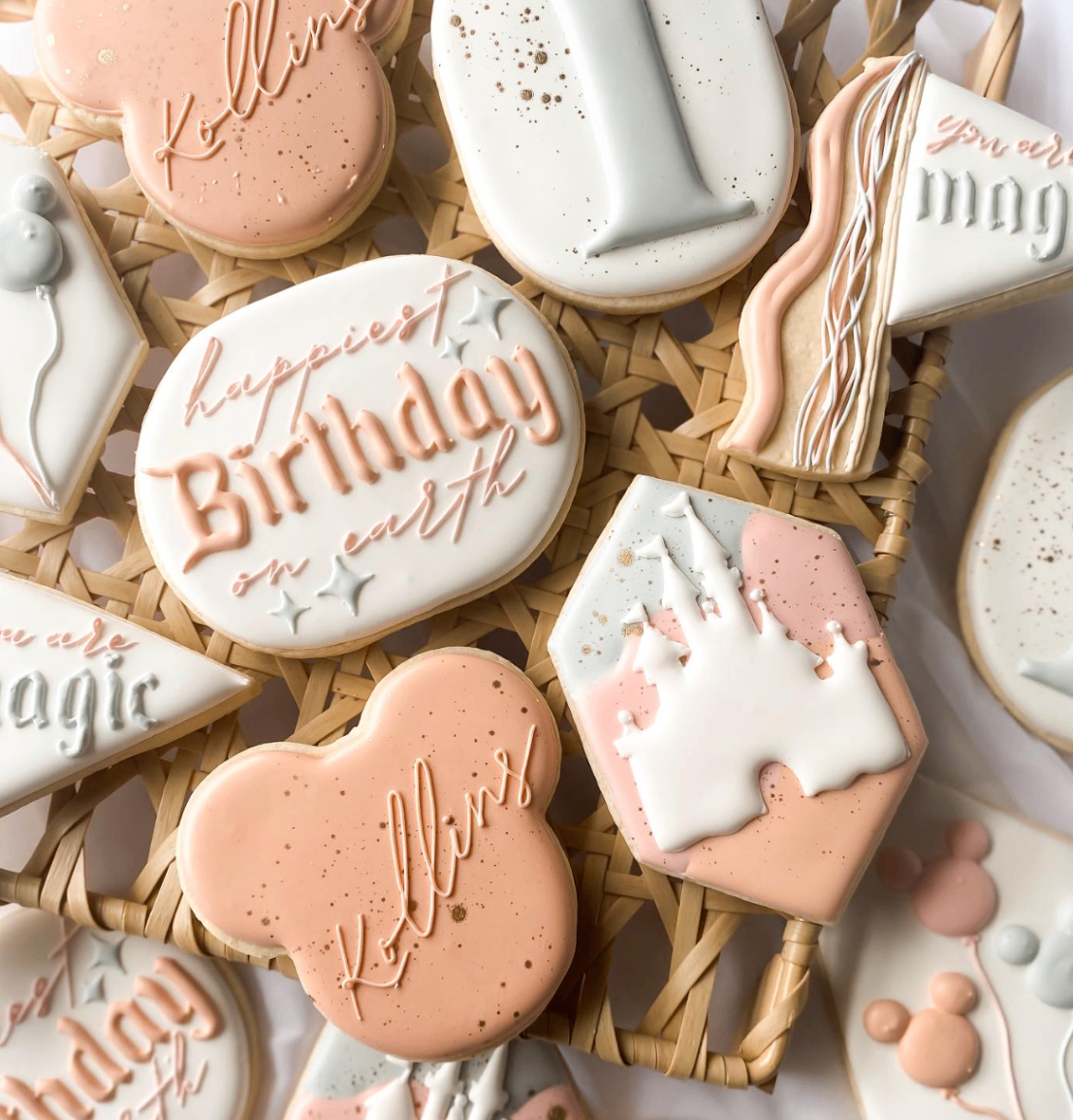 Blush celebration cookies with delicate lettering, soft speckling, and castle motif