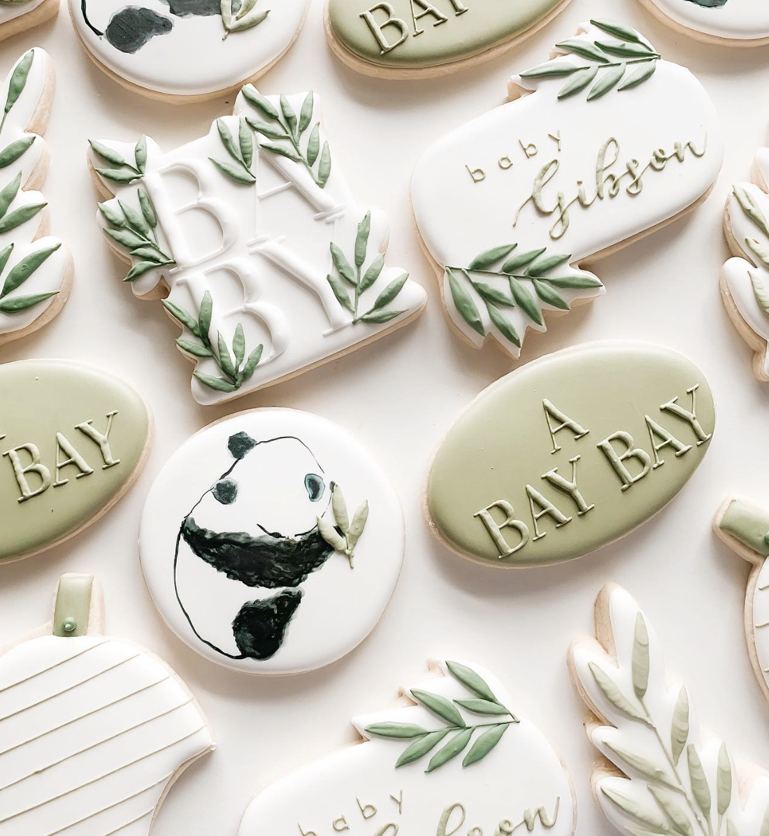 Sage green and white baby shower cookies with panda, olive leaves, and embossed baby lettering